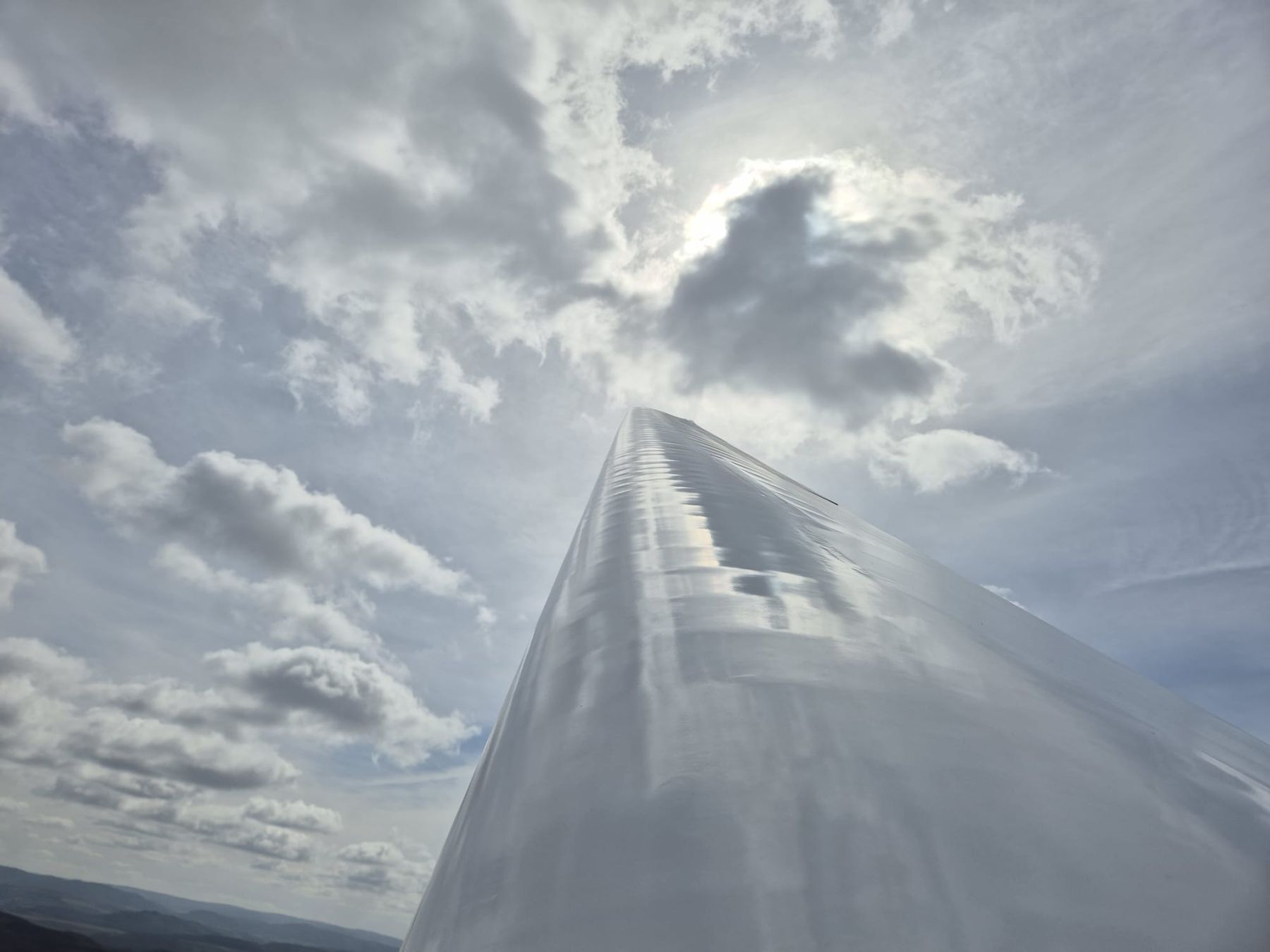 Tragfläche eines Segelflugzeugs vor sonnigen Wolken