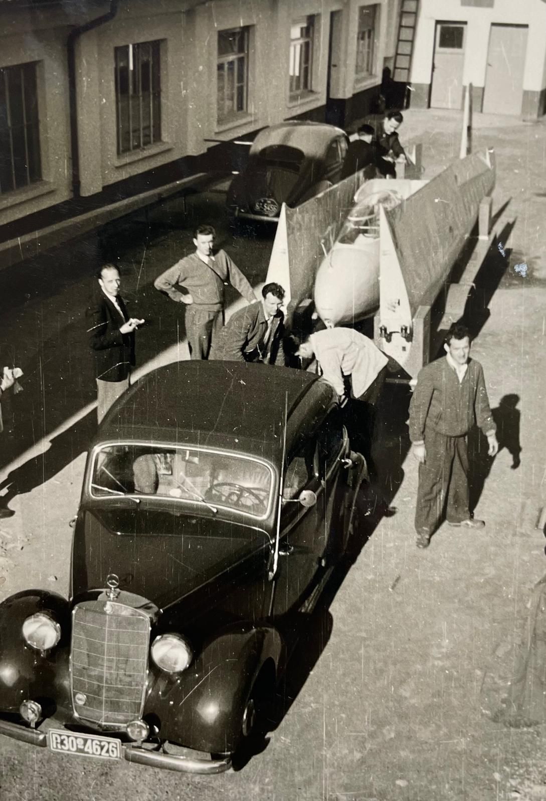 Historisches Foto: Mitglieder verladen ein Segelflugzeug in einen Anhänger hinter einem Mercedes