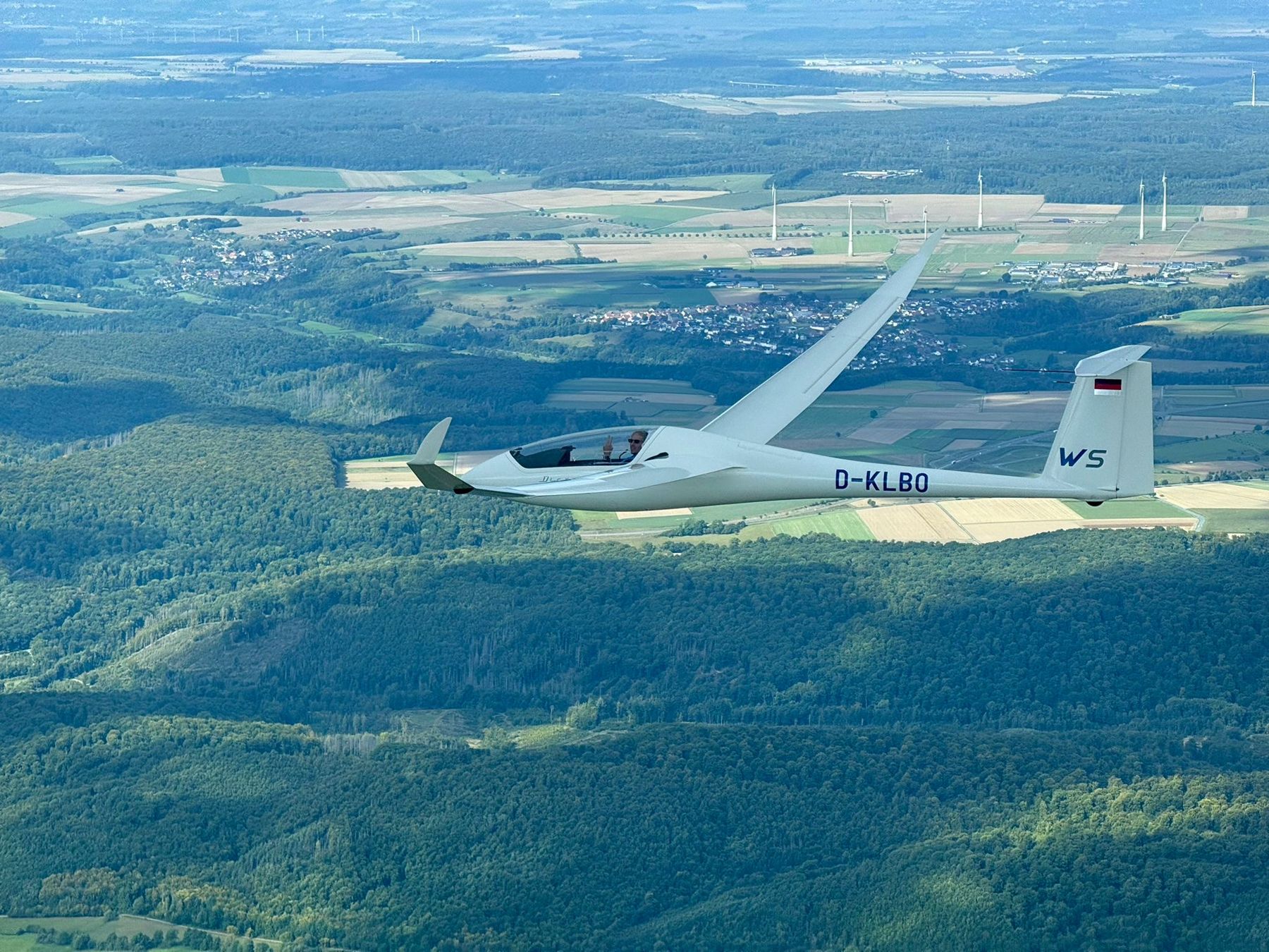 Pilot winkt aus dem Cockpit des Doppelsitzers